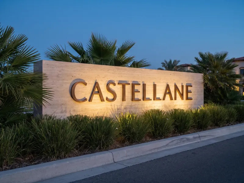 Illustration: stone monument sign with bronze letters reading CASTELLANE at a resort entrance