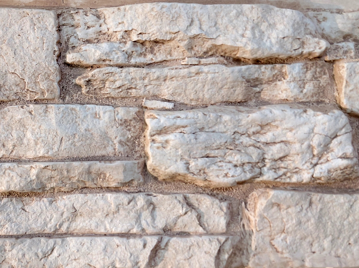 Close-up of a stone wall with varying stone sizes and colors.
